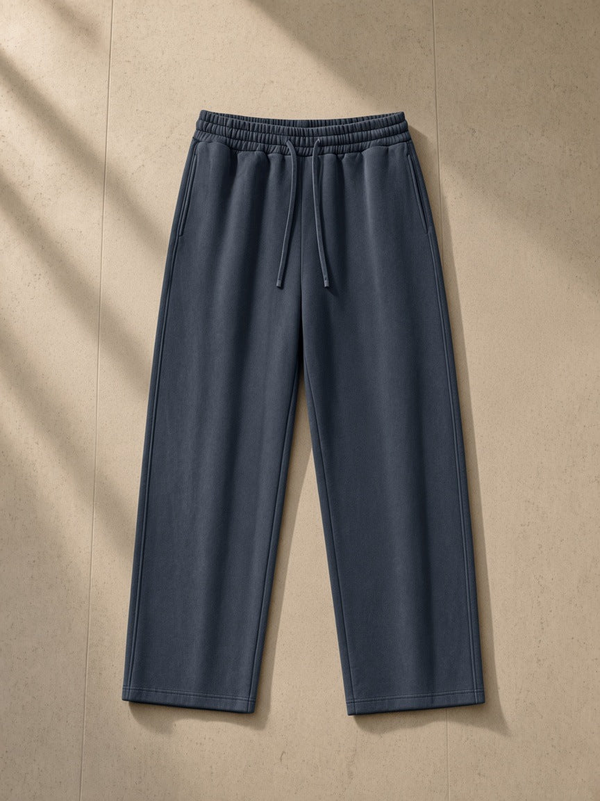Heavyweight vintage wash sweatpants in Washed Blue, laid flat on pale limestone