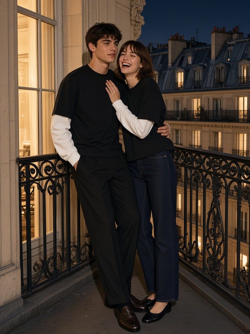 Marcel Afters Layered Contrast Sleeve Cotton T-Shirt in Black with White, worn by a man and a woman, embracing on a Paris balcony at night in black tees with white layered sleeves