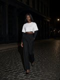 Woman in the Layered Contrast Sleeve Cotton T-Shirt in White with Black walking a cobblestone street in Tribeca, New York at night