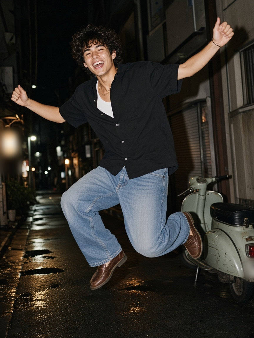 Man in the Marcel Afters Lightweight Cotton Short Sleeve Shirt in Black, jumping off a Vespa on a wet Tokyo backstreet at 2am