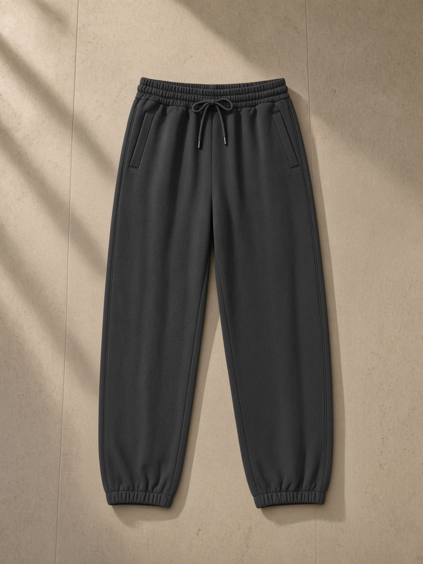Loose Fit Tapered Joggers in Dark Gray, laid flat on pale limestone, tapered leg with elastic ankle cuffs