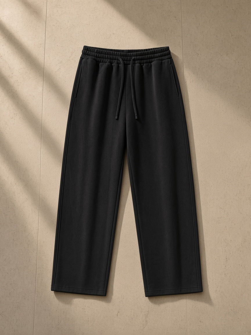 Loose Fit Tapered Joggers in Black, laid flat on pale limestone