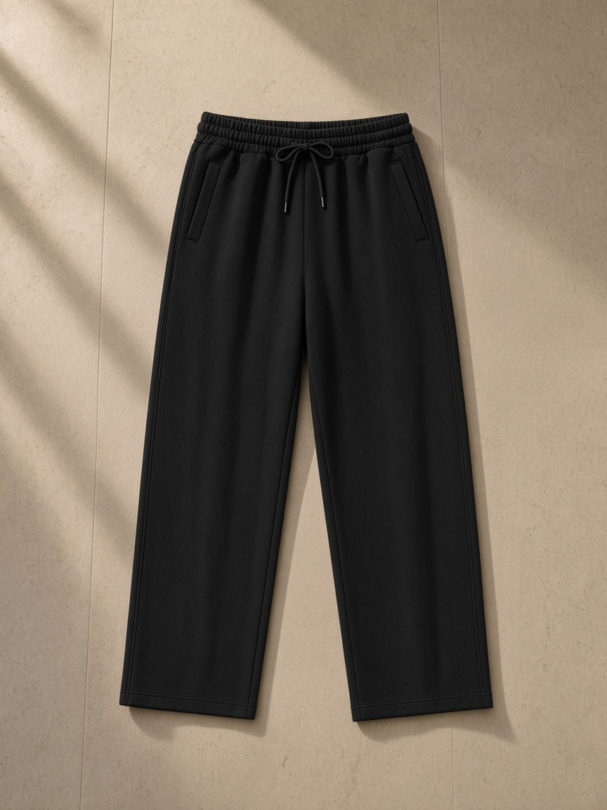 Loose Fit Tapered Joggers in Black, laid flat on pale limestone