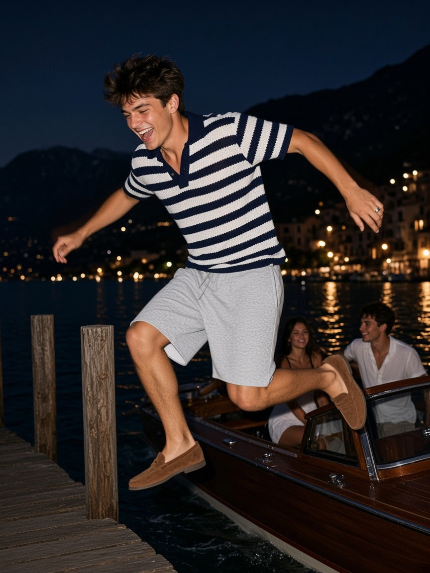 Man in the Raw Edge Loose Shorts in Flower Gray, leaping off a motorboat onto a Lake Garda jetty at midnight