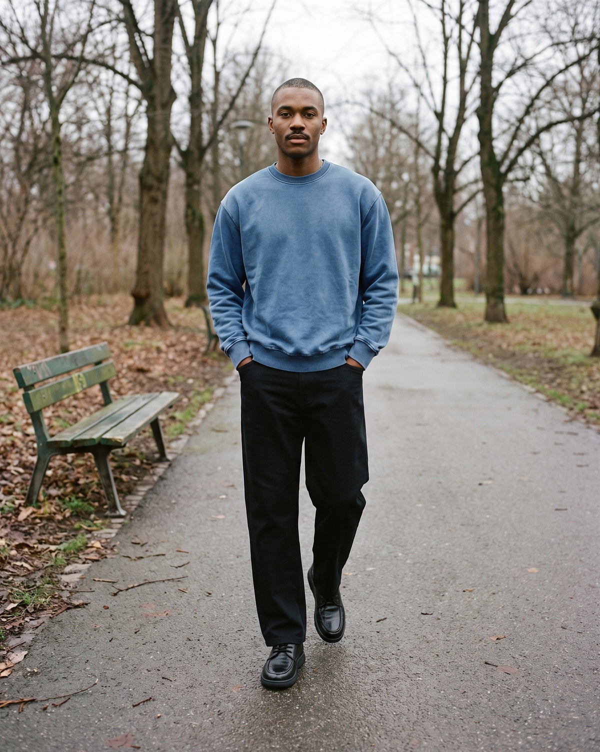 Man wearing The Back Stairs Lace-Up with the Snow Wash Oversized Crewneck Sweatshirt in Black, Heavyweight Straight-Leg Trousers in Black. Weekend Uniform, Autumn–Winter 2026 campaign