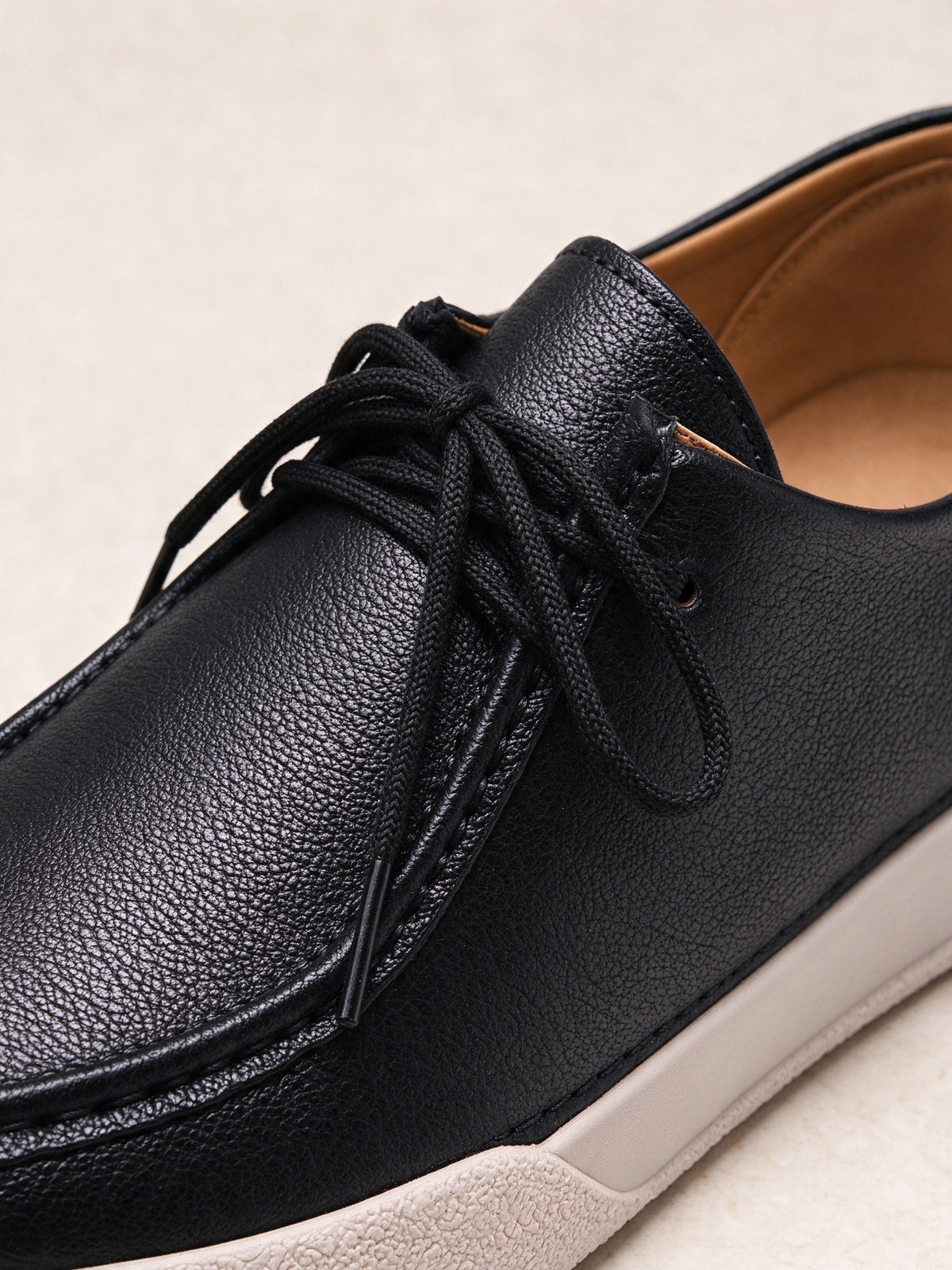 The Afterparty Lace-Up in black, detail shot of the leather grain, laces and cream sole