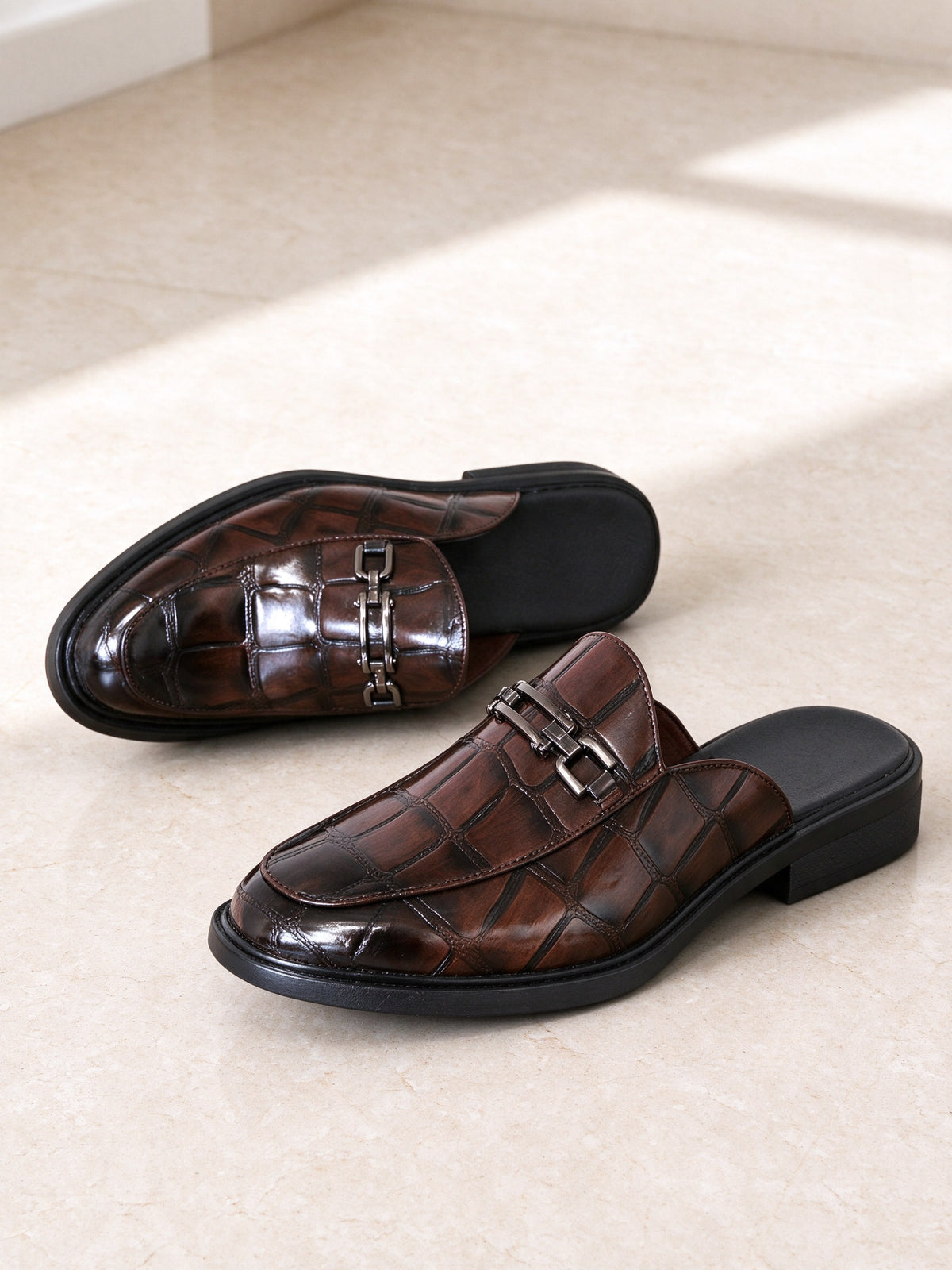 The Room Key Mule in brown, pair on a pale limestone studio floor