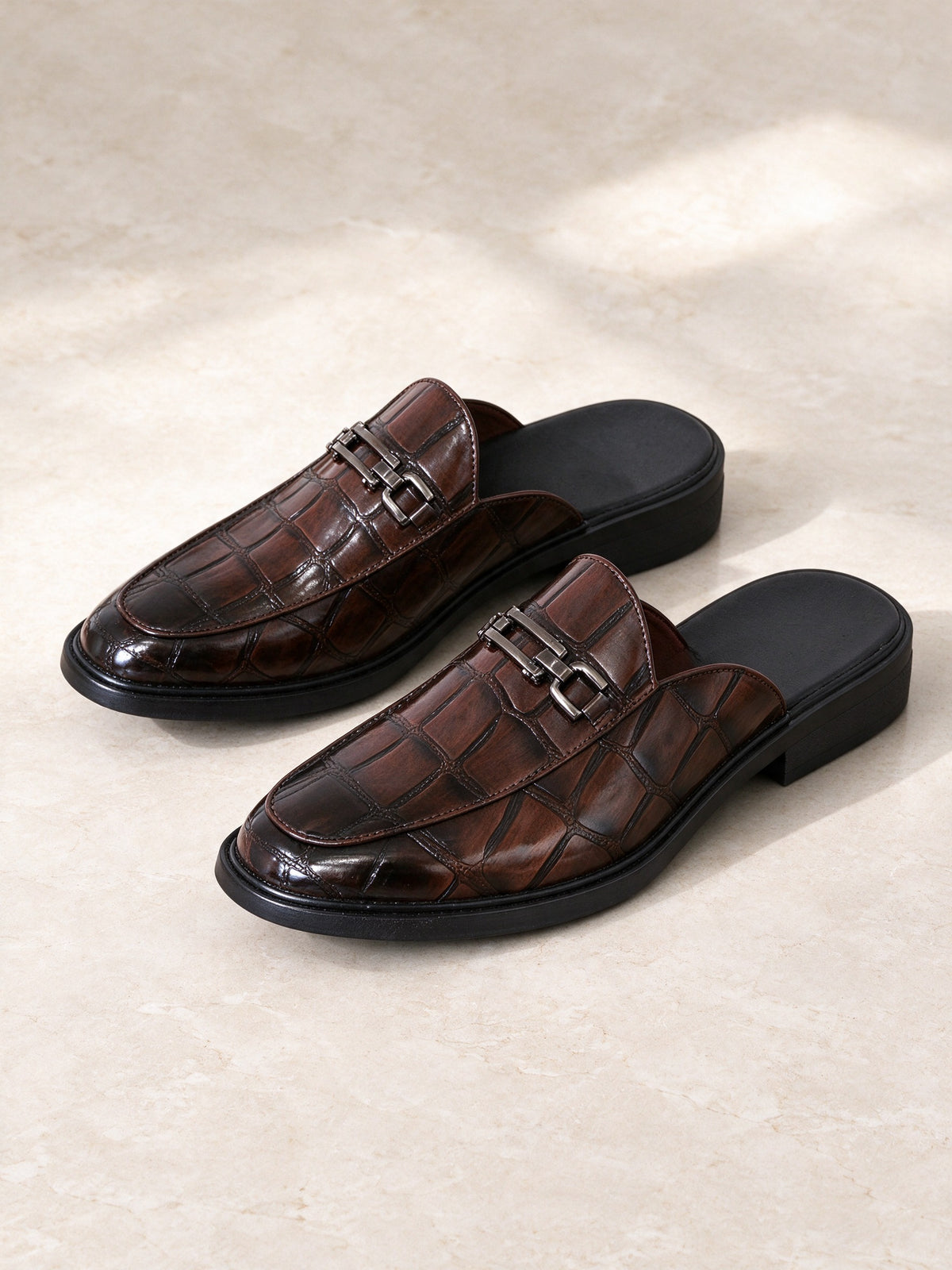 The Marcel Afters The Room Key Mule, a pair on a pale stone floor in soft daylight