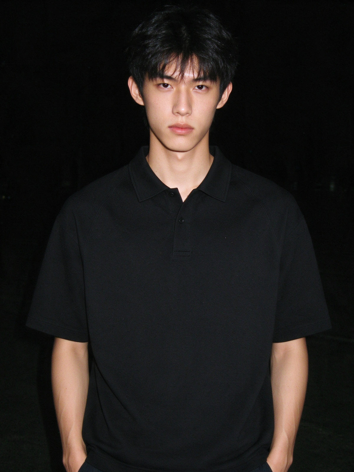 Man wearing the Classic Knit Polo in Black, full-length model photo