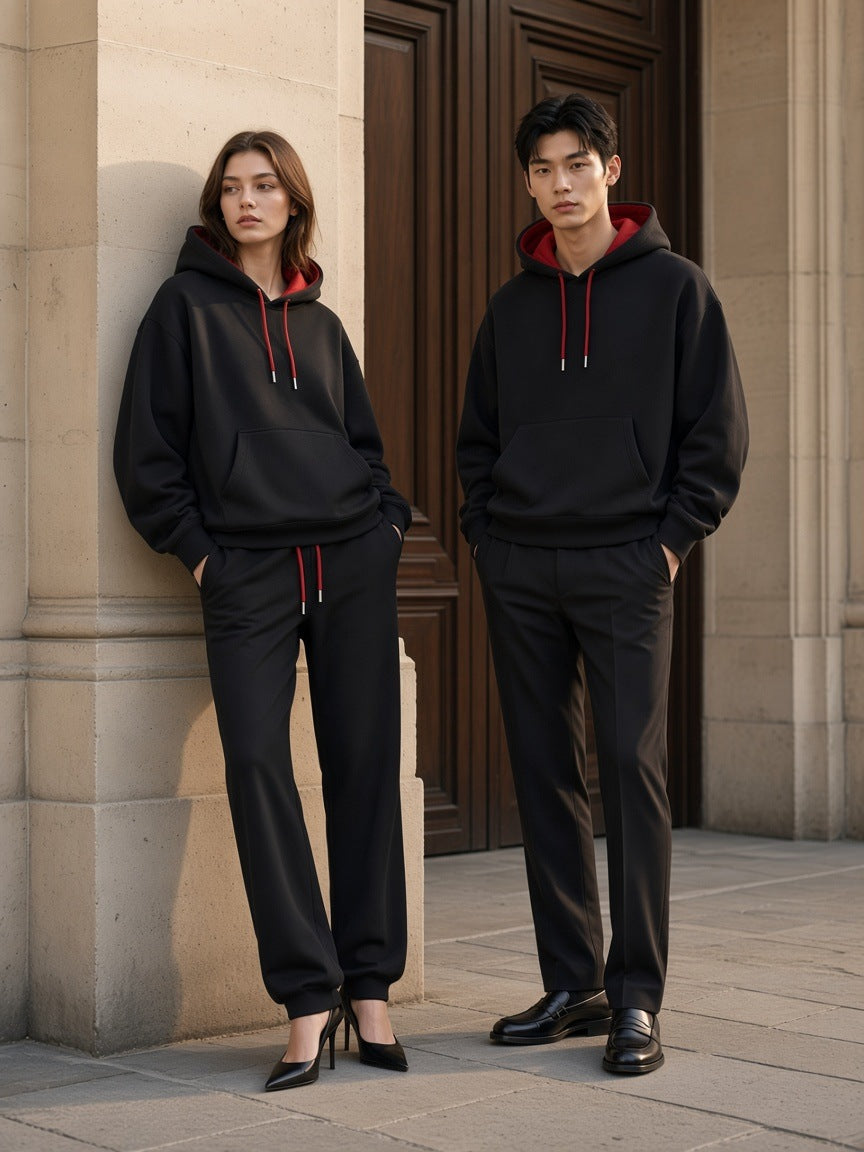 Marcel Afters Contrast Drawstring Hoodie in Black, worn by a man and a woman, standing shoulder to shoulder by a stone doorway in matching black hoodies