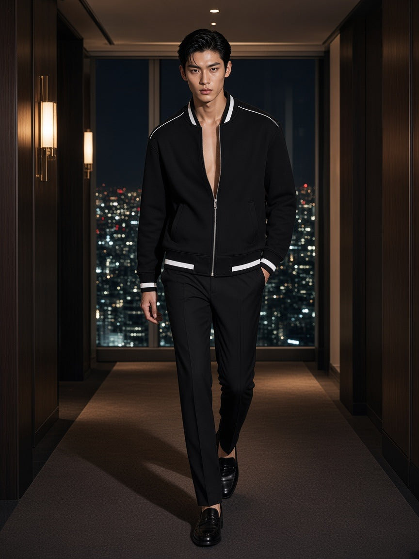 Marcel Afters Contrast Piping Zip Bomber Jacket in Black, worn by a man, walking a dark hotel corridor above the city lights