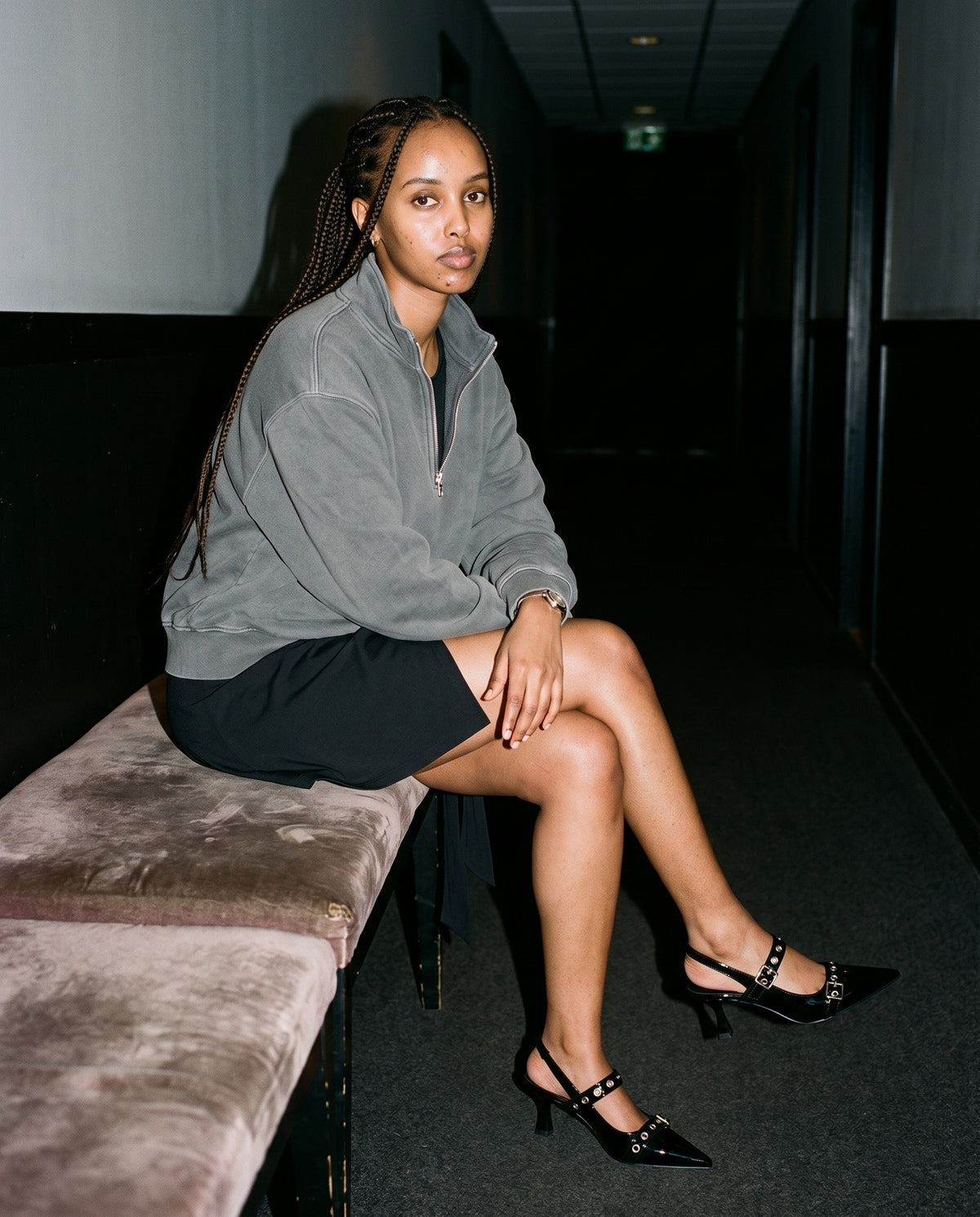 Woman wearing The Do Not Disturb Slingback with the A-Line Sleeveless Dress in Black, Vintage Wash Fleece Quarter Zip Sweatshirt in Gray. Past Midnight, Autumn–Winter 2026 campaign