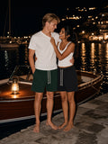 Two people wearing the Drawstring Shorts in Dark Green and Black, full-length model photo