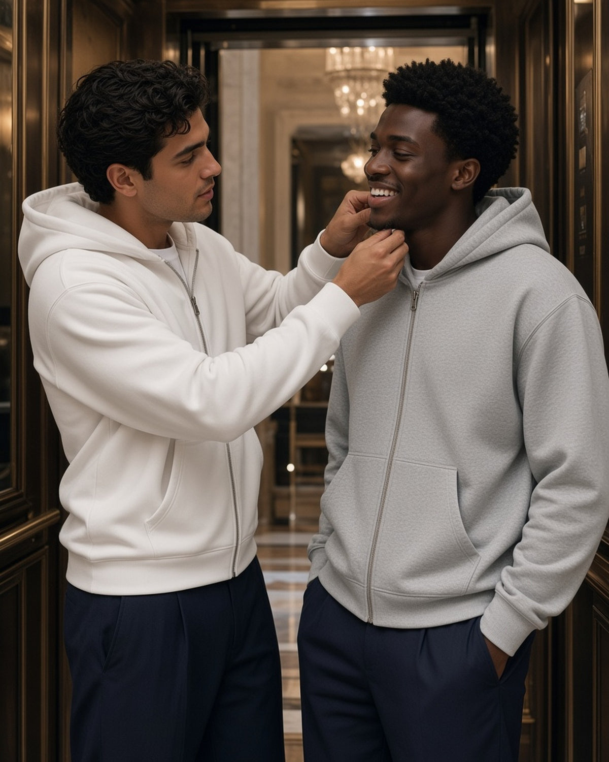 Two men in the Drop Shoulder Full Zip Hoodie in White and Flower Gray in a grand-hotel lift