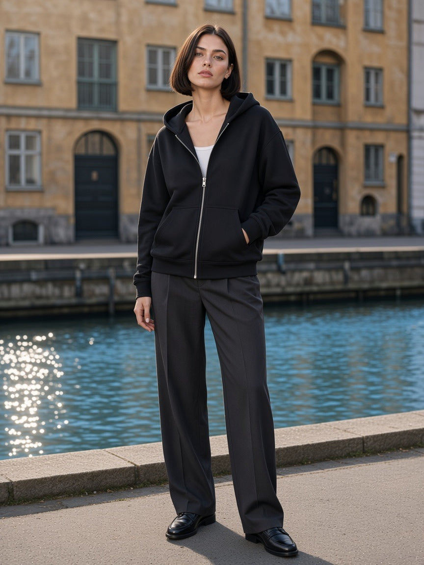 Marcel Afters Drop-Shoulder Zip Up Hoodie in Black, worn by a woman, city canal
