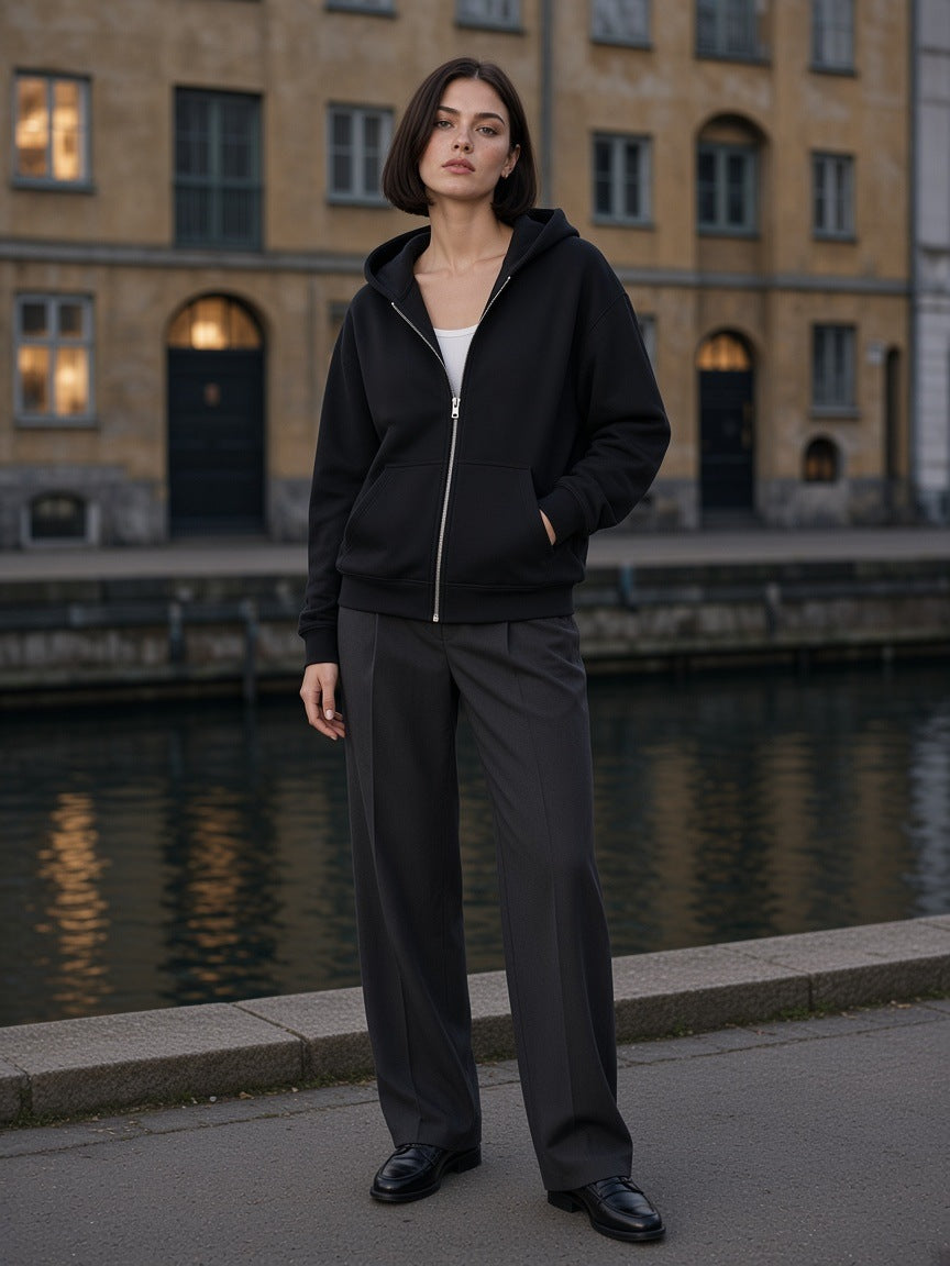 Marcel Afters Drop-Shoulder Zip Up Hoodie in Black, worn by a woman, city