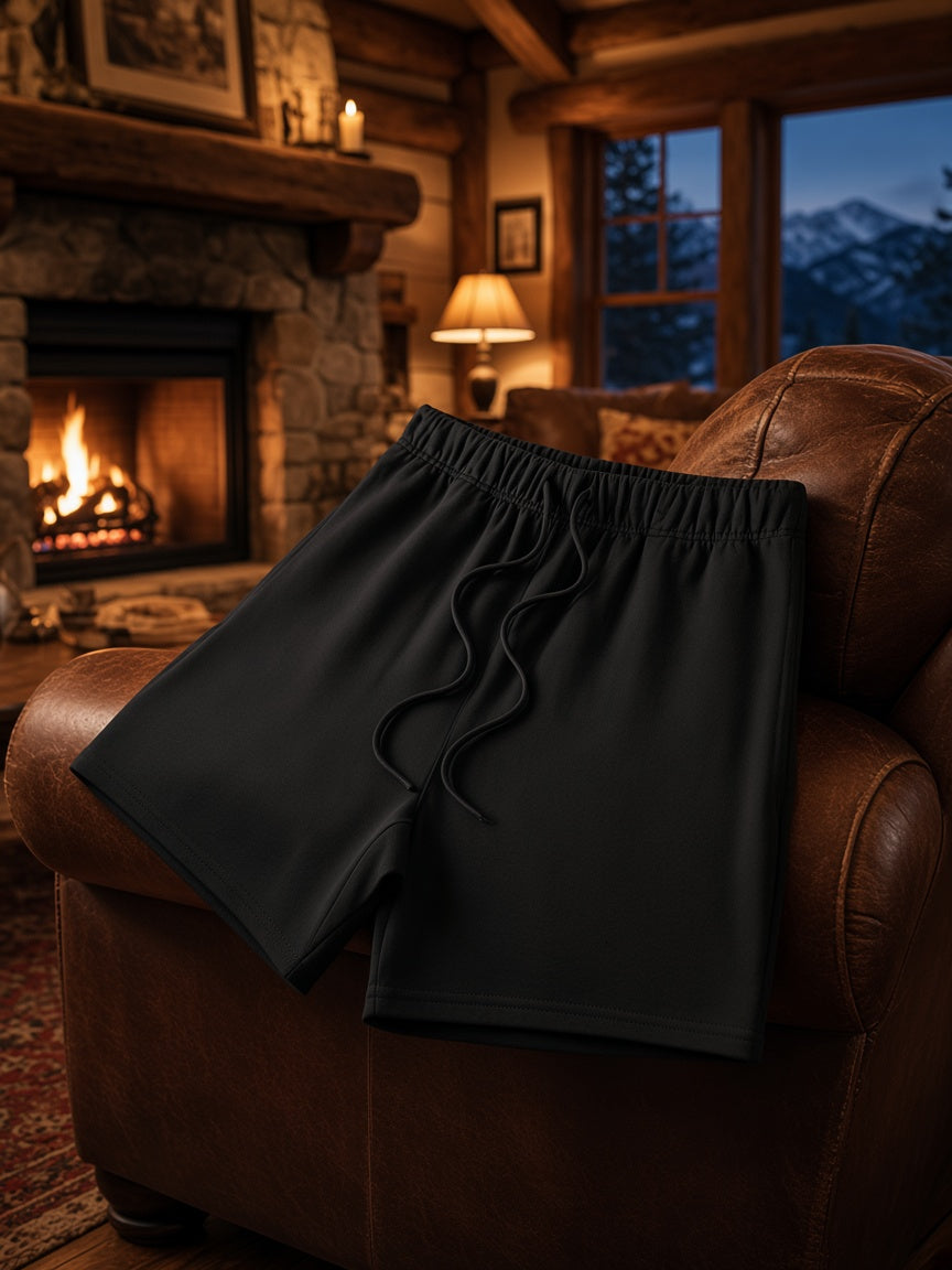 Marcel Afters Earth Tone Loose Fit Cotton Shorts in Black, worn by a man, living room