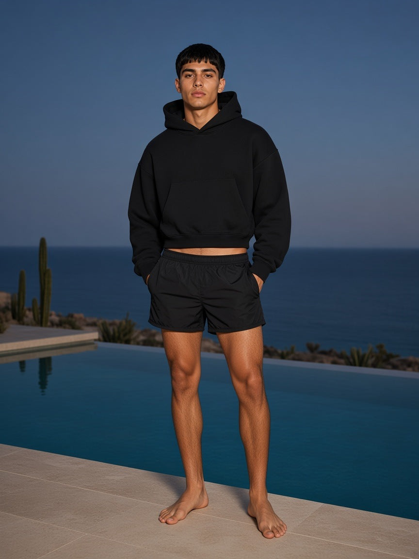 Marcel Afters Essential Boxy Darted Sleeve Hoodie in Black, worn by a man, ocean