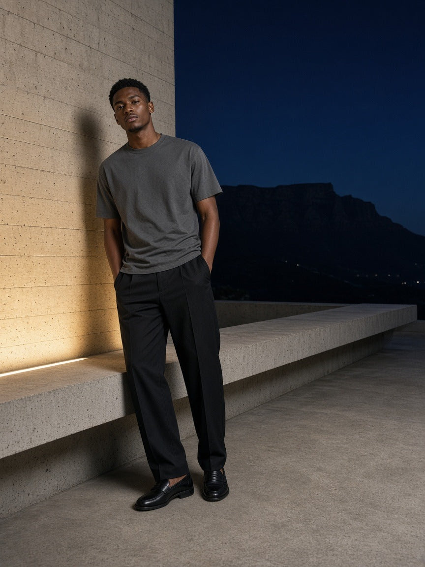 Marcel Afters Essential Cotton Boxy T-Shirt in Dark Gray, worn by a man, concrete wall