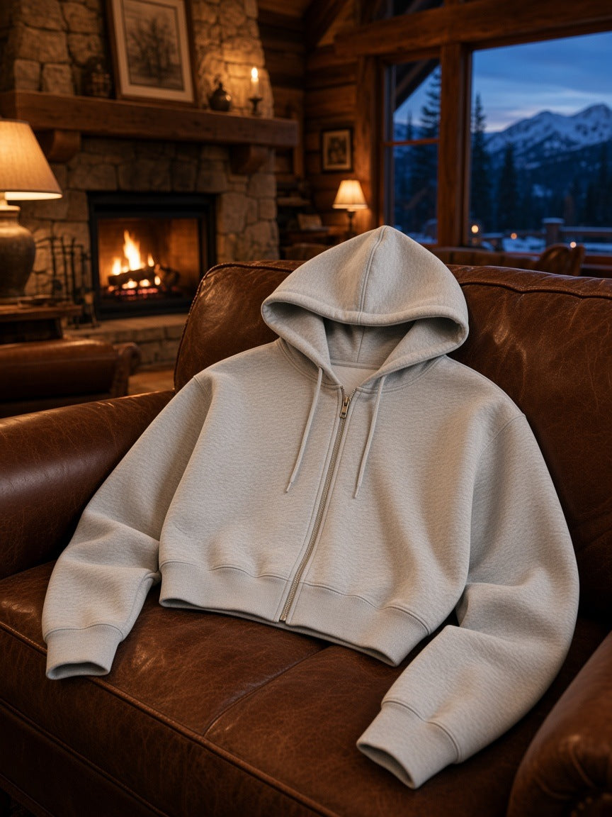 Marcel Afters Essential Cropped Zip-Up Hoodie in Oat Gray, laid flat, living room