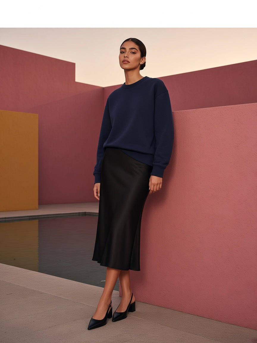 Marcel Afters Essential Heavyweight Crewneck Sweatshirt, 400 gsm in Navy Blue, worn by a woman, standing in a terracotta courtyard in a long black satin skirt