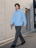 Man wearing the Essential Heavyweight Drop-Shoulder Hoodie in Sky Blue, full-length model photo