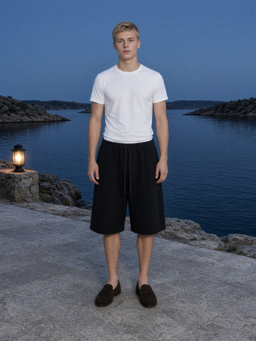 Man wearing the Essential Heavyweight Fleece Shorts in Black, full-length model photo