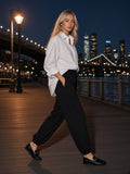 Marcel Afters Essential Jogged Sweatpants in Black, worn by a woman, city
