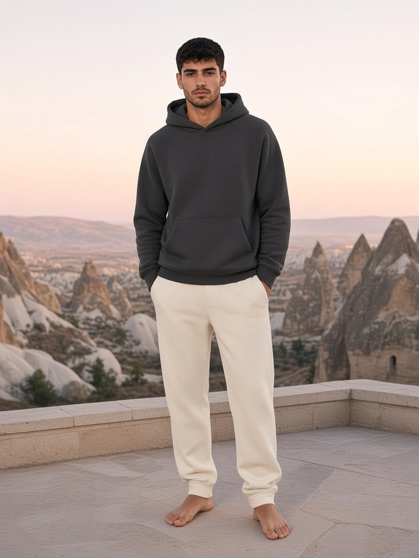 Marcel Afters Essential Raglan Sleeve Fleece Hoodie in Cement Gray, worn by a man, rooftop