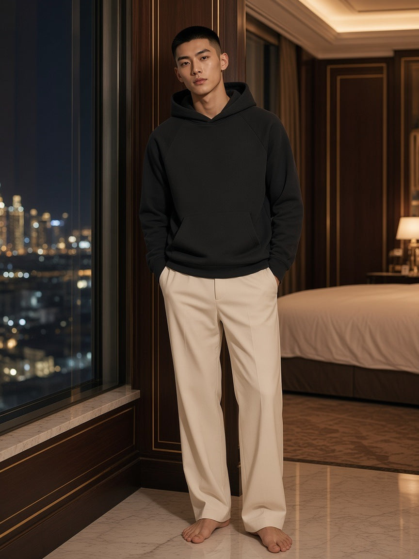 Marcel Afters Essential Raglan Sleeve Fleece Hoodie in Black, worn by a man, hotel room