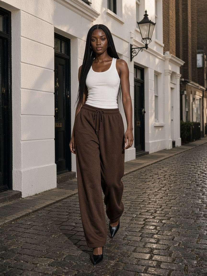 Marcel Afters Fleece Drawstring Straight-Leg Sweatpants in Brown, worn by a woman, cobbled street