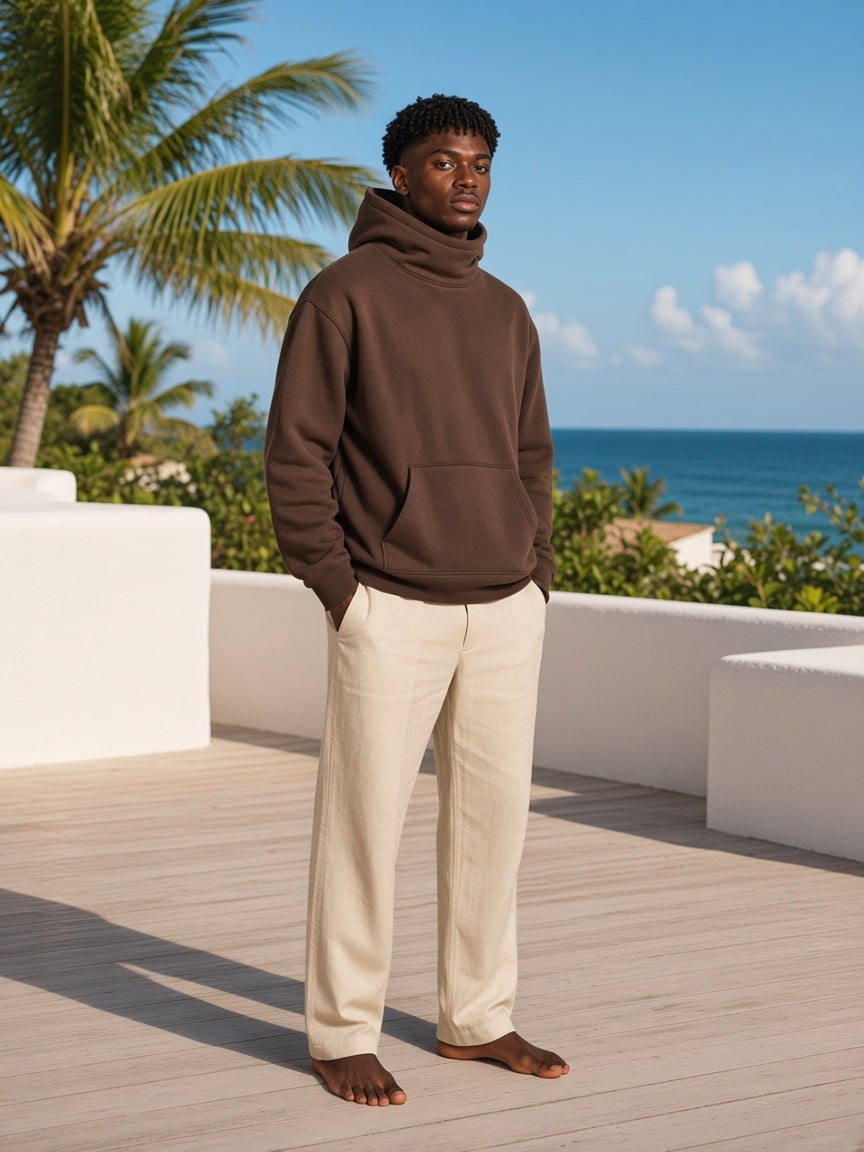 Marcel Afters Fleeced High Neck Hoodie in Brown, worn by a man, beach