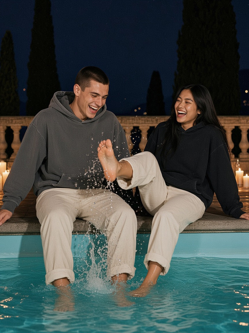 Two people wearing the Frayed Enzyme Washed Fleece Hoodie in Dark Gray and Black, full-length model photo