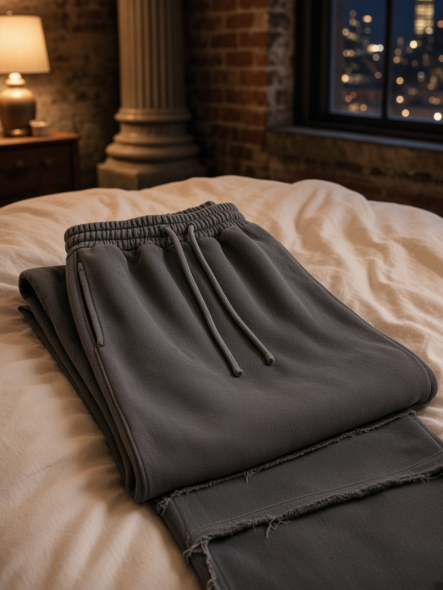 Marcel Afters Frayed Enzyme Washed Fleece Sweatpants in Dark Gray, laid flat, bedroom