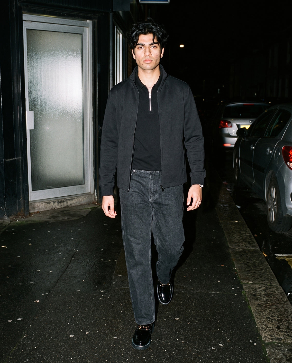 Man wearing the Marcel Afters Half-Zip Cotton Polo in Black, full-length editorial photograph