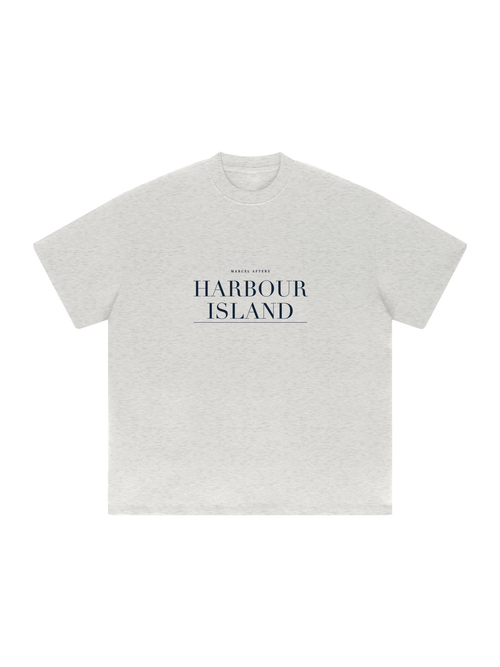 Harbour Island heavyweight drop-shoulder tee in Oat Gray, front view with the island name in navy across the chest. Marcel Afters.