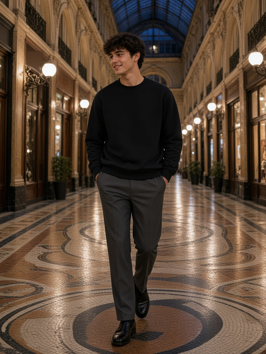 Marcel Afters Heavyweight Crewneck Sweatshirt in Black, worn by a man, walking a mosaic-floored glass arcade