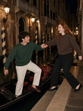 Marcel Afters Heavyweight Crewneck Sweatshirt in Blackish Green, worn by a man and a woman, stepping between gondolas on a lamp-lit canal at night, he in green and she in brown