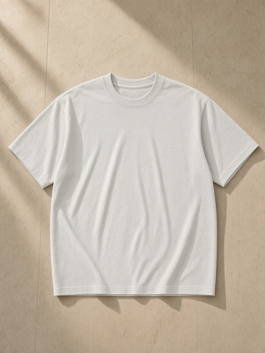 Heavyweight Drop Shoulder T-Shirt in Oat Gray, laid flat on pale limestone
