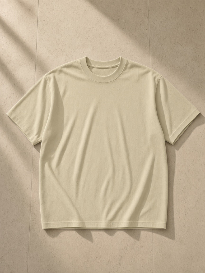 Heavyweight Drop Shoulder T-Shirt in Pale Khaki, laid flat on pale limestone