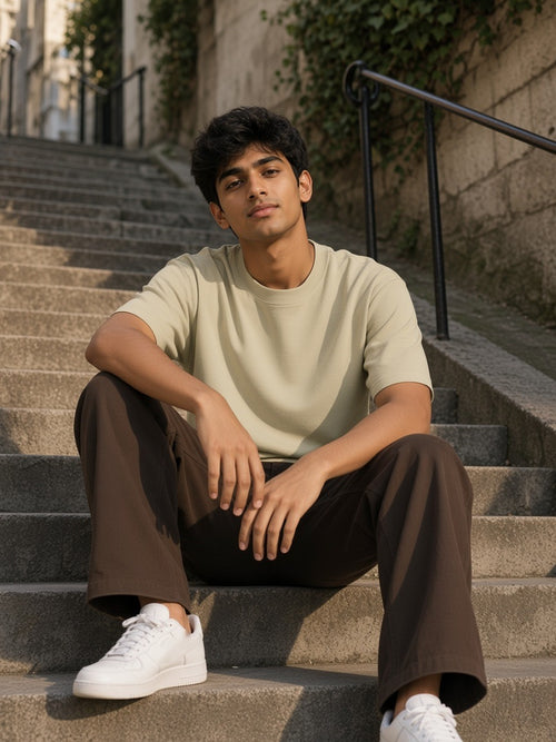 Man in the Heavyweight Drop Shoulder T-Shirt in Pale Khaki sitting on the Montmartre steps in late-afternoon sun
