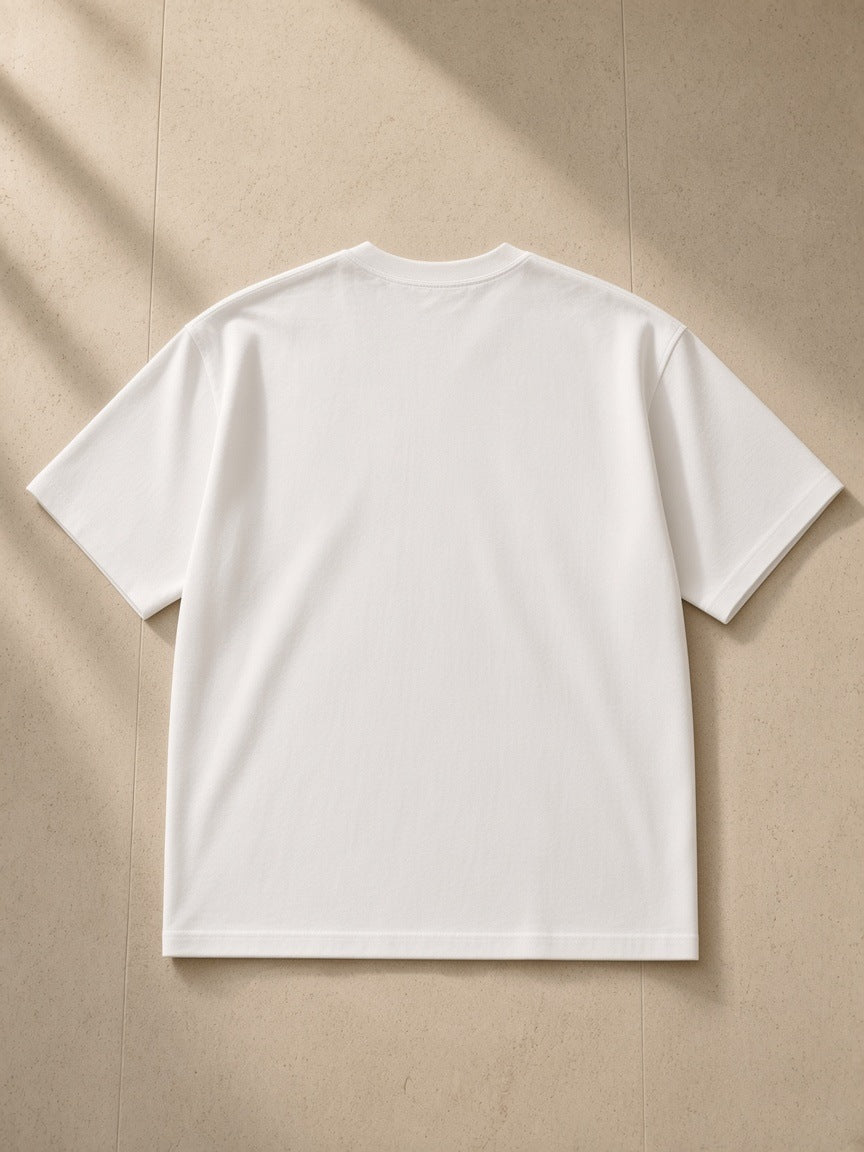 Heavyweight Drop Shoulder T-Shirt in White, laid flat on pale limestone, back view