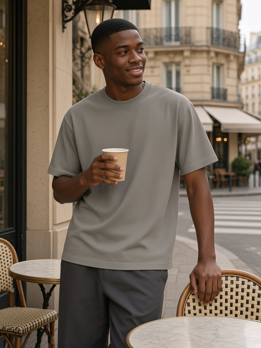 Man in the Heavyweight Earth Tone T-Shirt in Gray Camel with a coffee on a Paris café terrace in the afternoon
