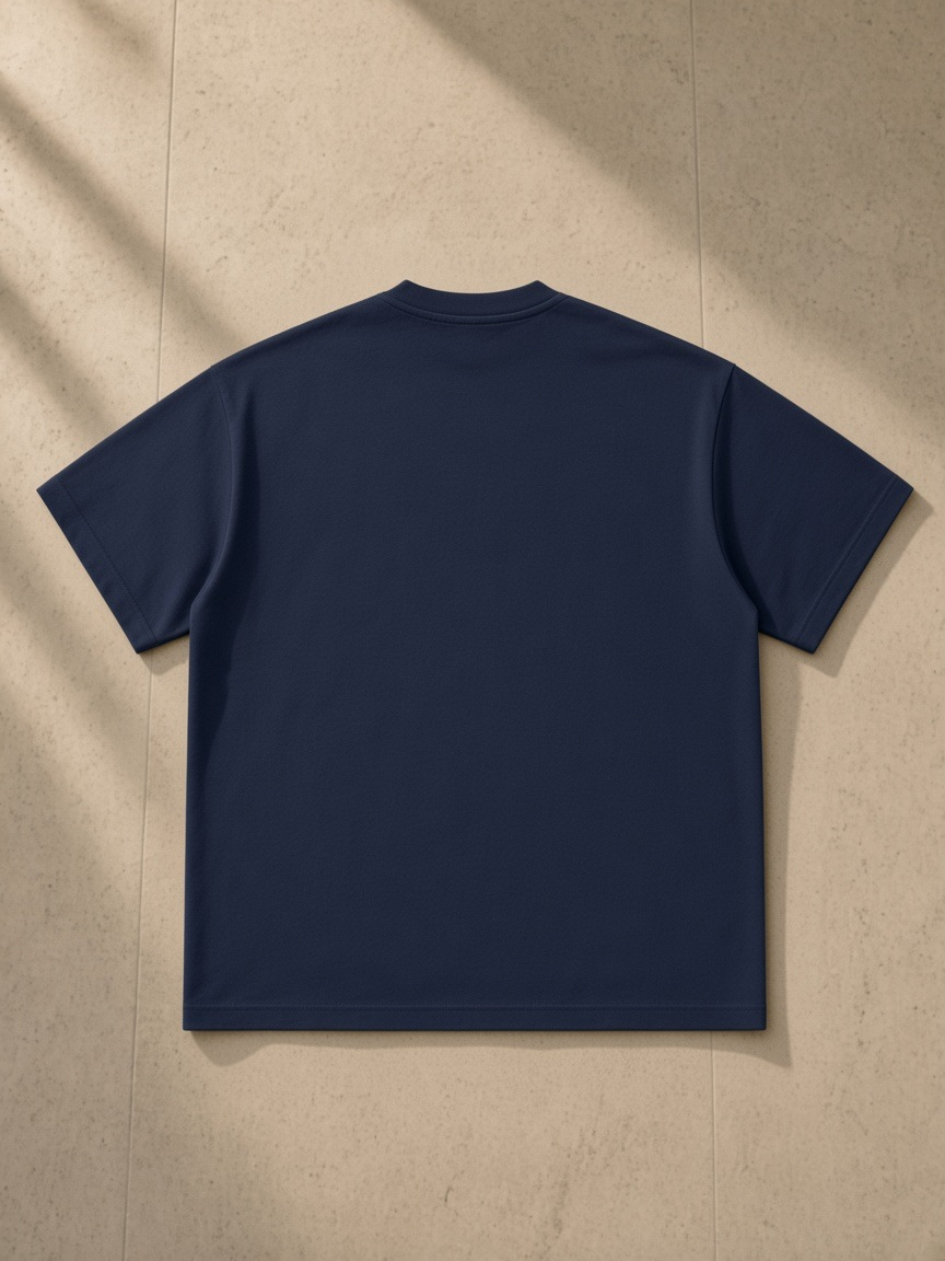 Heavyweight Earth Tone T-Shirt in Navy, laid flat on pale limestone, back.
