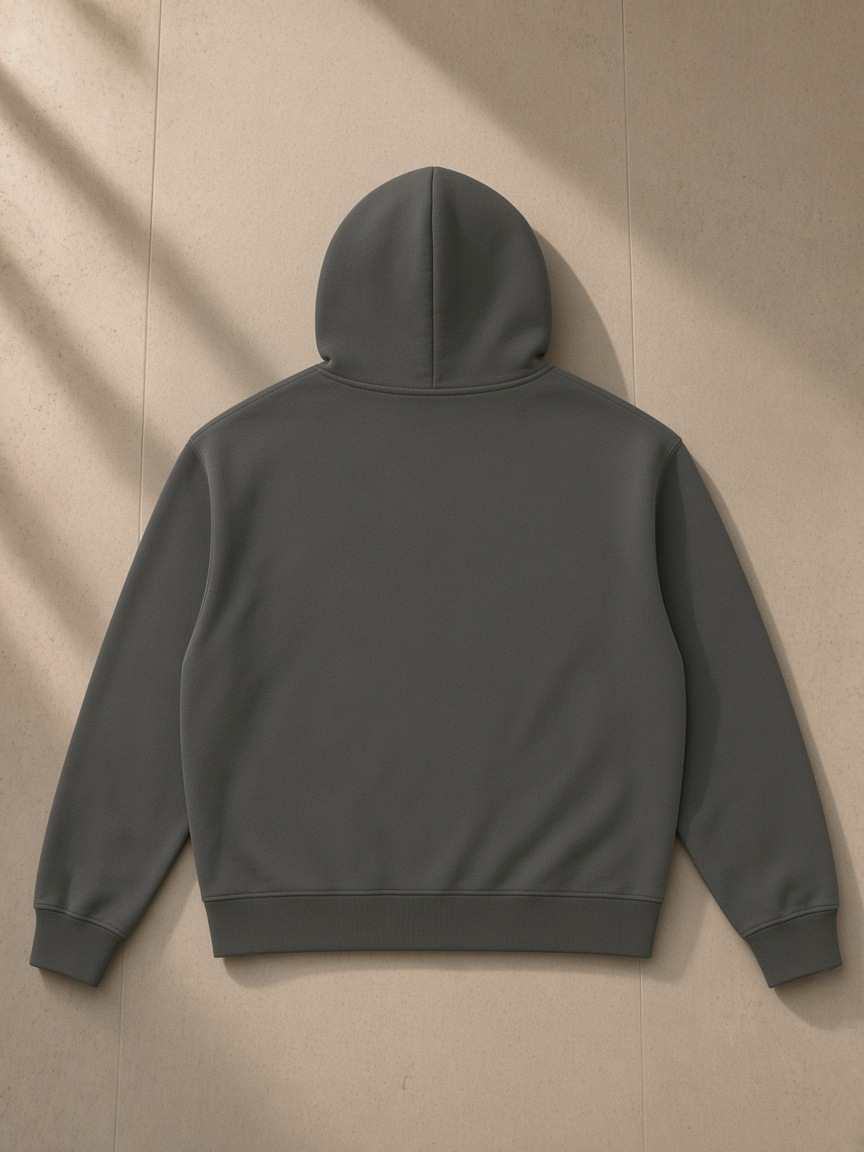 Heavyweight boxy full-zip hoodie in Dark Gray, laid flat on pale limestone, back view