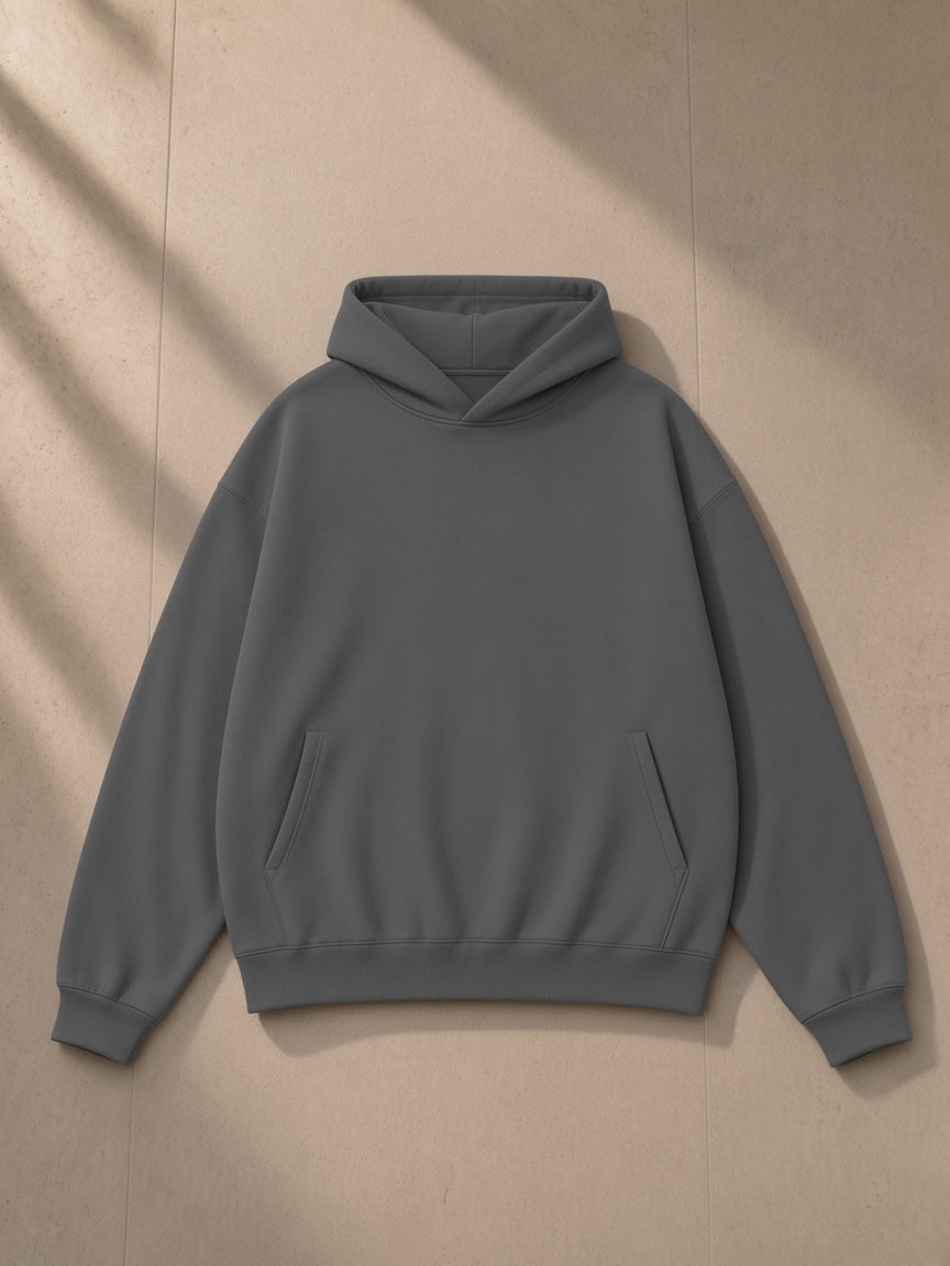 Unisex heavyweight hidden pocket fleece hoodie in Charcoal, laid flat on pale limestone, front view