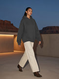 Woman in the heavyweight hidden pocket fleece hoodie in Charcoal walking through a desert lodge courtyard in Utah at night