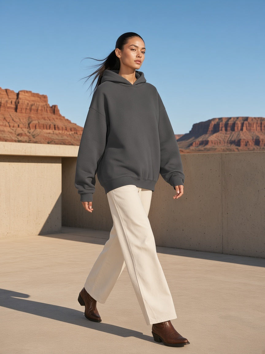 Marcel Afters Heavyweight Hidden Pocket Fleece Hoodie in Charcoal, worn by a woman, desert