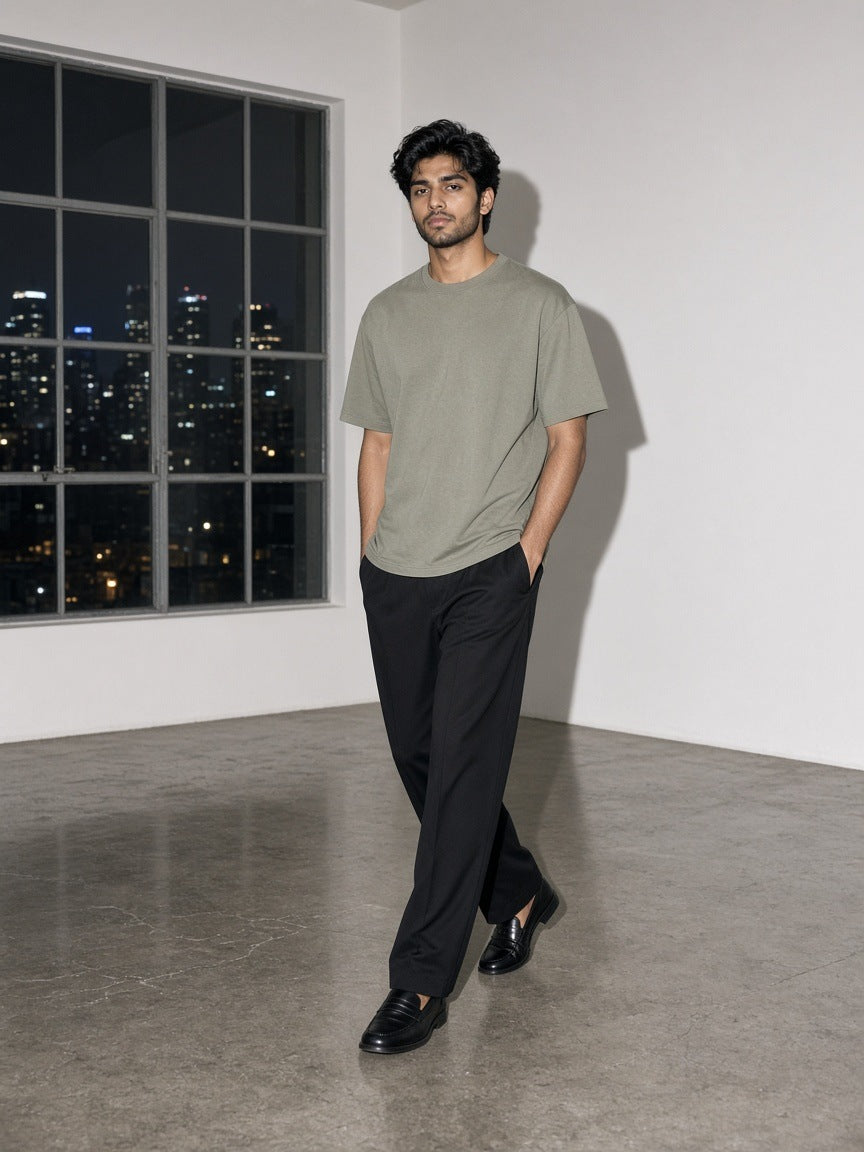 Marcel Afters Heavyweight Loose Fit T-Shirt in Greyish Green, worn by a man, white room