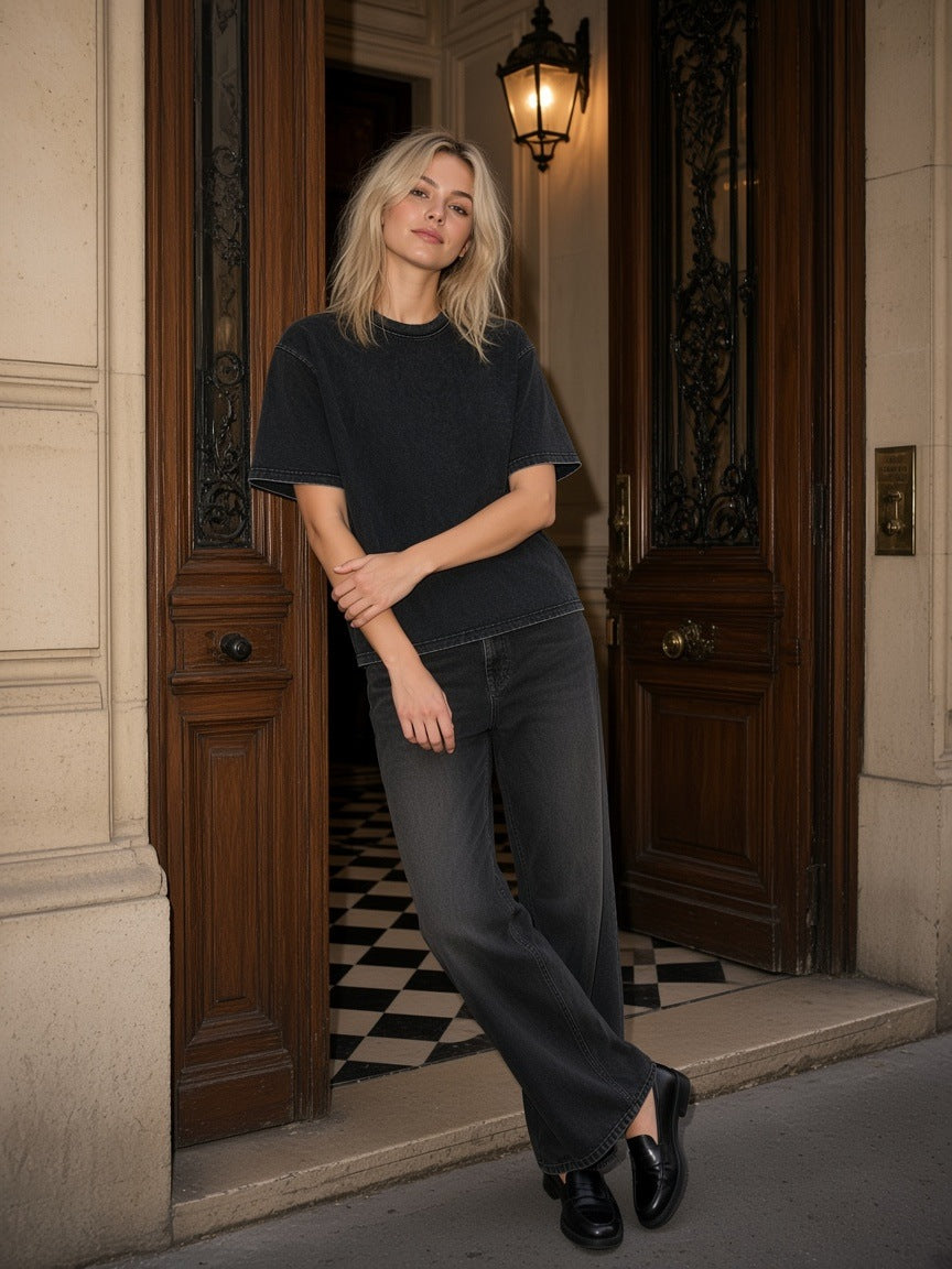 Woman in the Heavyweight Mineral Wash Boxy T-Shirt in Black in a carved Paris doorway at night